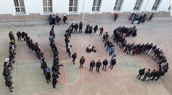 Demonstrators position themselves to spell out 