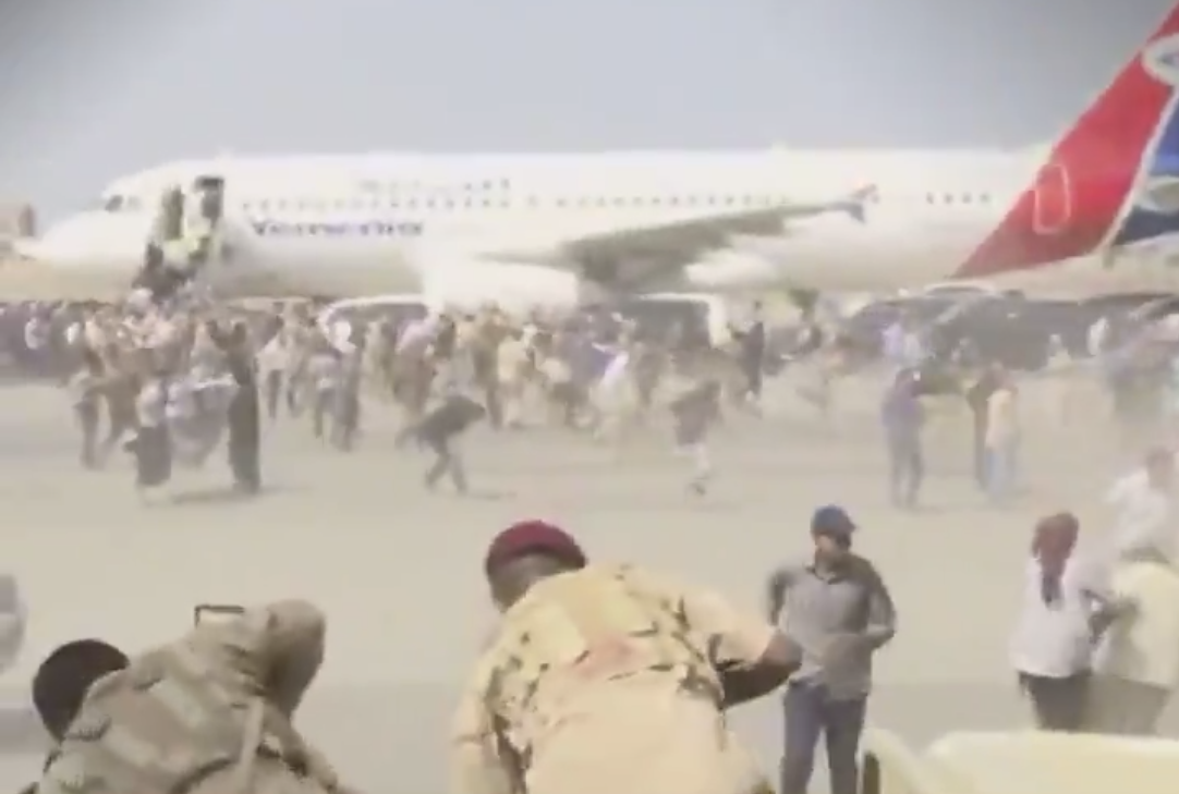 Crowds scurrying moments after the first explosion at Aden airport
