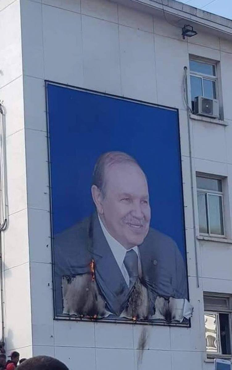 A poster of Bouteflika, partially burned by protesters