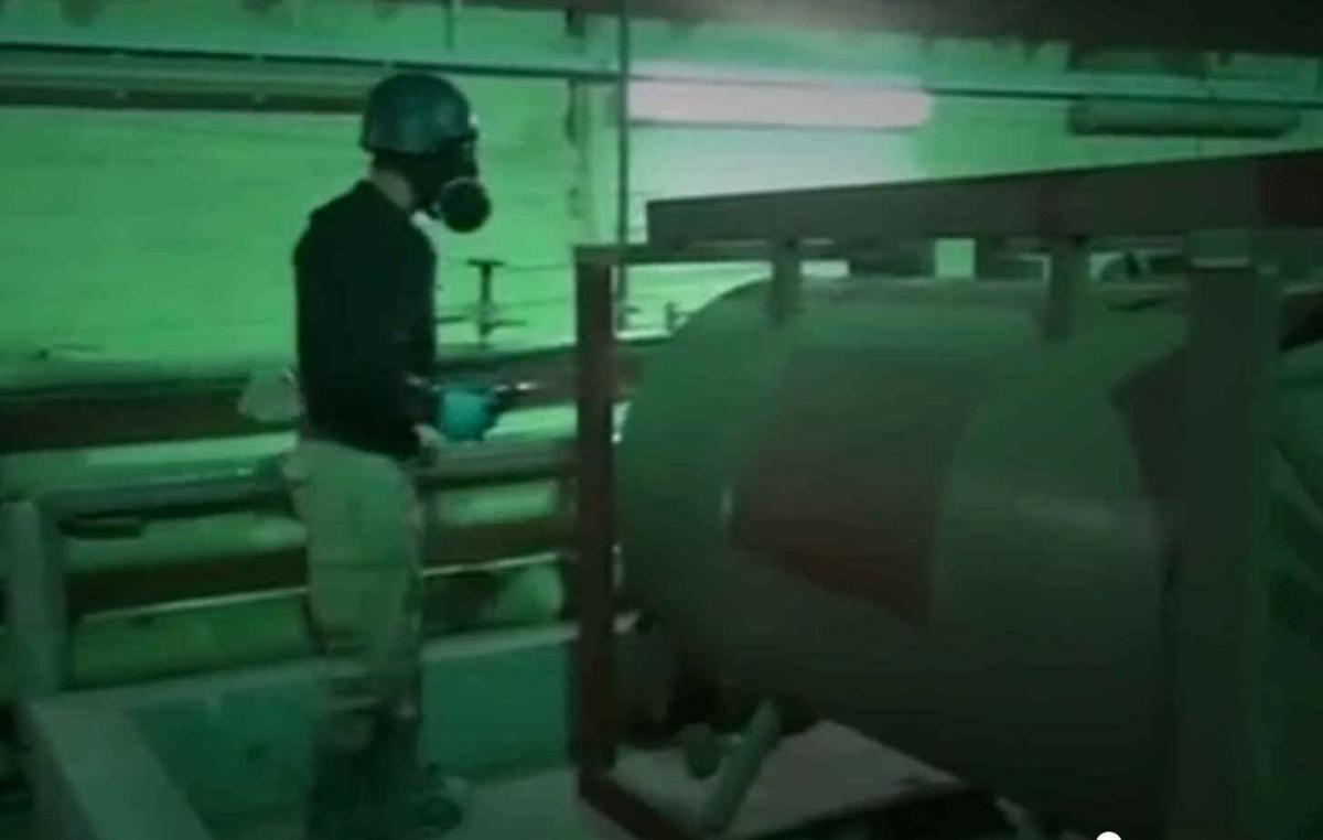 An inspector from OPCW examines tanks used in Syria's chemical weapons programme