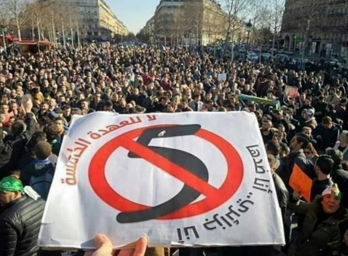 This crossed-out number 5 conveys a clear and simple message. The words say "No to the fifth term. I am Algerian, I am against it."