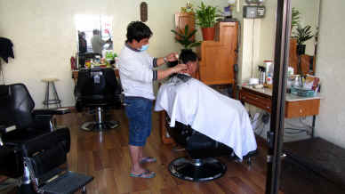 Al-Khobar, Saudi Arabia. A man gets a haircut at a Filipino barbershop. Photo: Nadine Compton